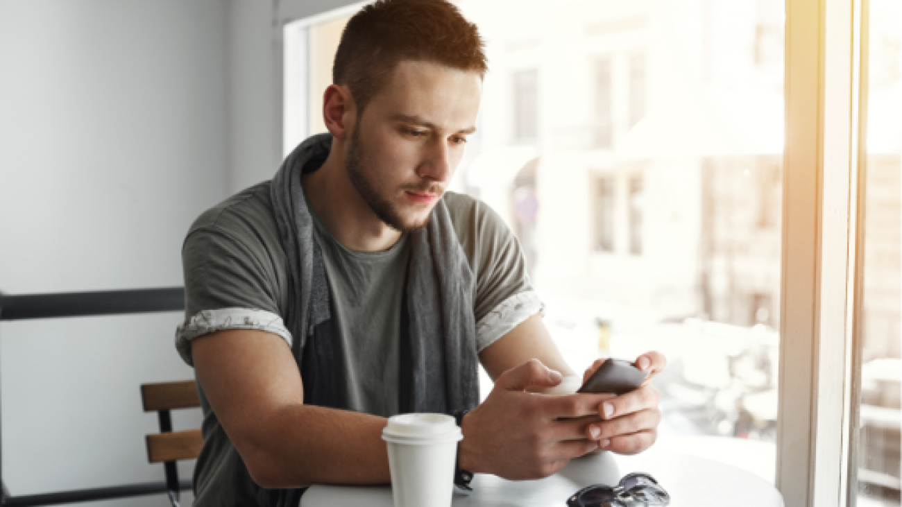 closeup-guy-sitting-table-cafe-texting-message-1